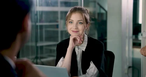 Young female executive smiling while participating in group meeting, Stock Footage 314218248