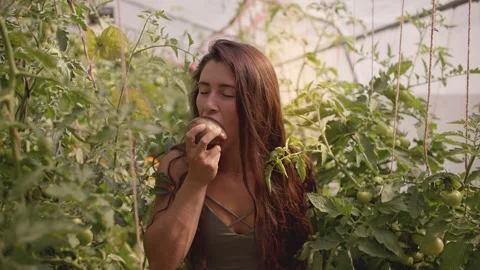 Young female farmer taking a bite out of vegetable 库存影片 213489717