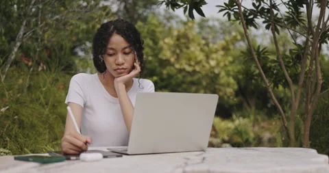 Young female freelance sitting doing online business on laptop in park. Stock Footage 247903353