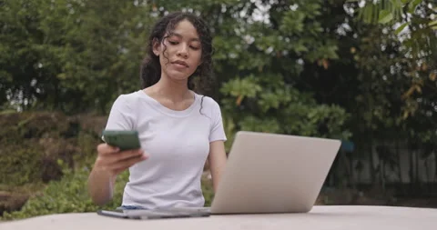 Young female freelance sitting doing online business on laptop in park. Stock Footage 247907643