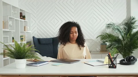 Young female freelancer is starting work with laptop and sitting at table in Stock Footage 185505474