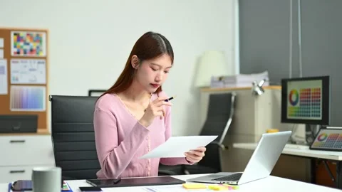 Young female graphic designer using digital tablet and laptop in modern off.. Video stock 312436791