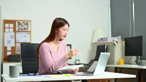 Young female graphic designer using digital tablet and laptop in modern off.. Video stock 312849283