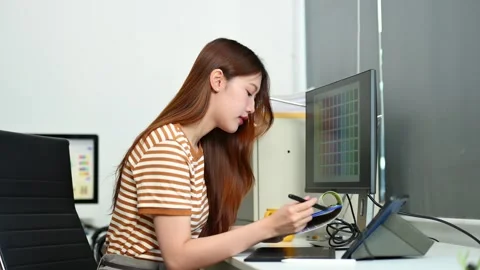 Young female graphic designer using digital tablet and laptop in modern off.. Stock Footage 312849340