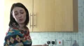 Young female haing a discussion as she makes tea HD Footage