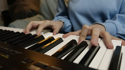 Young female hands learning playing electric piano. Woman fingers on keys. Stock Footage 129323605