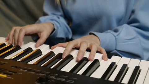 Young female hands learning playing electric piano. Woman fingers on keys. Stock Footage 129325489