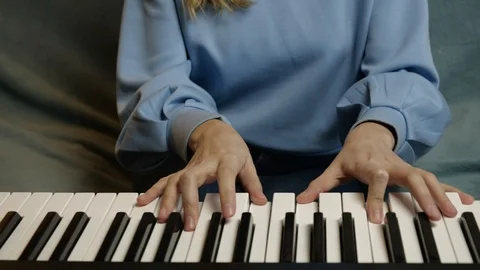 Young female hands learning playing electric piano. Woman fingers on keys. Stock Footage 129325639