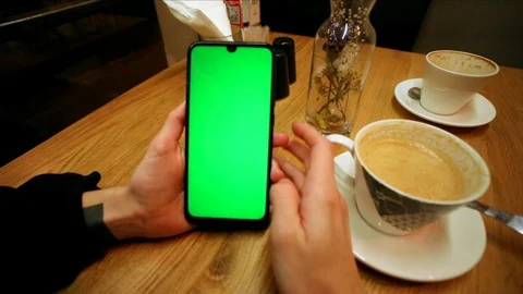 Young female hands using green screen smartphone sitting in cafe drinking coffee 스톡 동영상 121741404