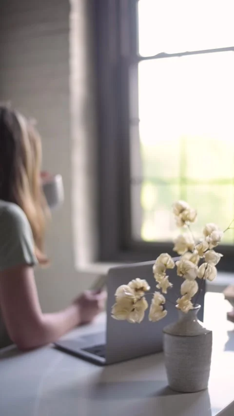 Young female has coffee in front of her computer in a home office Stock Footage 218267290