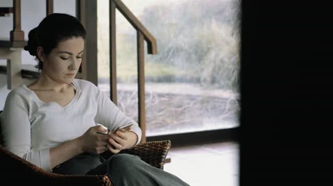 Young female with her smart phone.Thinking about something. Indoors shot Stock-Footage 59840215