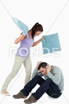 Young female hitting her boyfriend with pillows Stock Photos