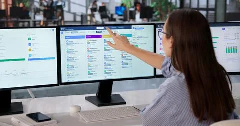 Young Female HR Manager Using Computer Screens To Review Employee Data Effici Foto stock