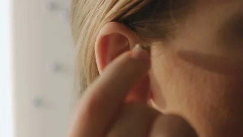 Young Female Inserts Her Right Hearing Aid In Her Ear Stock Footage 85567035