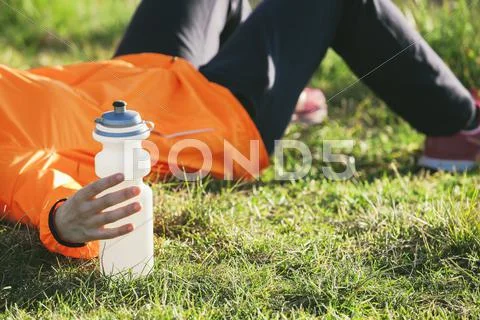 Young female jogger having a break on a meadow Stock Photos