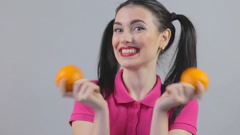 Young female knocks on oranges and laughs Stock Footage 73441306