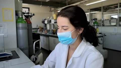Young female lab technician making up to volume with yellow liquid into a mea 스톡 동영상 134287846