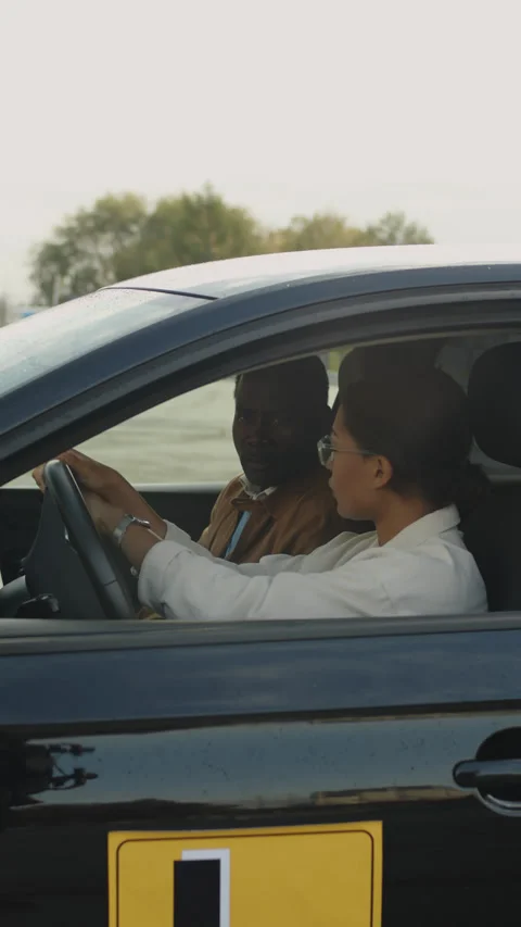 Young Female Learner Studying Driving under Guidance of Instructor Stock Footage 276539056