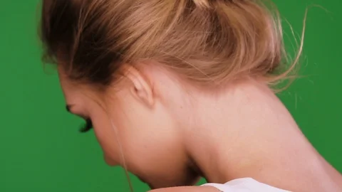 Young female looking from her back on green background Stock Footage 109798061