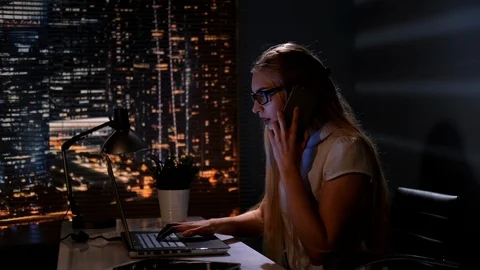 Young female manager working on the computer and speaking with somebody by Stock Footage 113809079