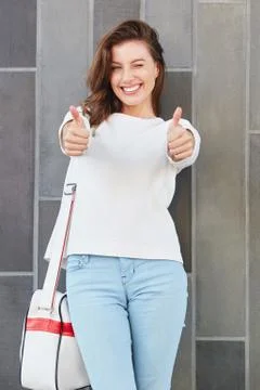 Young female model gesturing thumbs up sign Stock Photos