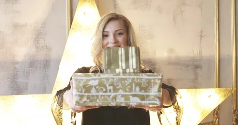 Young female model smiling and giving Christmas gift boxes. Stock Footage 82620895