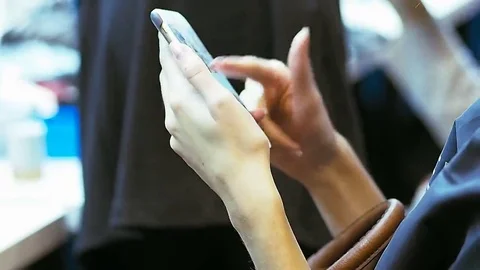 Young female model use a mobile phone while waiting for the hair stylist 스톡 동영상 69077838