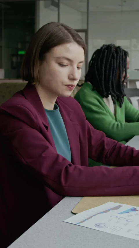 Young Female Office Worker Checking Financial Report and Typing on Laptop Stock Footage 333569798