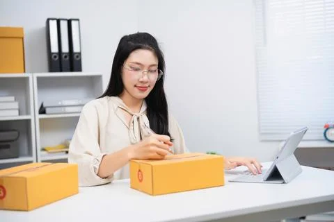 Young Female Office Worker Packaging and Managing Shipping Orders with Elec.. Stock Photos