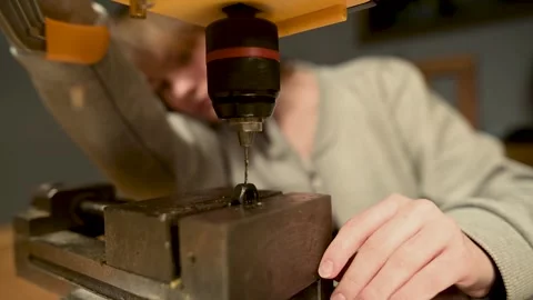 Young female operating a drill press in the workshop crafting handmade jewelry. Vidéo 271152317