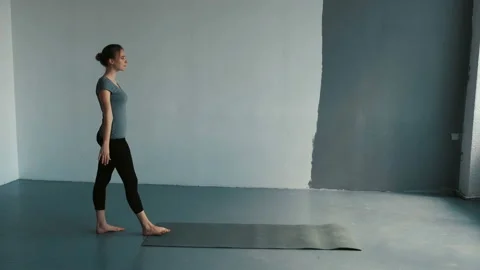 Young female performs a backflip with hands in the spacious ballroom. Flexible Stock Footage 107332095