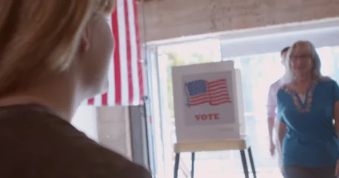 A young female poll worker processing voters Stock Footage 274996448