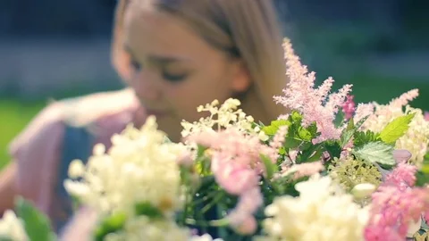 Young female posing camera plays to stare down the camera hiding in flowers on Stock Footage 83570152