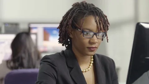 Young female professional working at a computer in an office Stock Footage