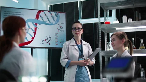 Young female professionals study genetic material and discuss molecular biology Video stock 307343725