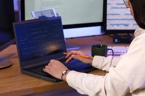 Young female programmer with cup of coffee and laptop working in modern offic Stock Photos
