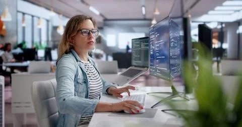 Young Female Programmer Developing Secure Software On Laptop In Modern Office Fotos Stock