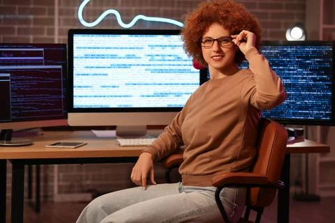 Young female programmer at her workspace in office at night Stock Photos