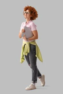 Young female programmer with laptop on grey background Stock Photos