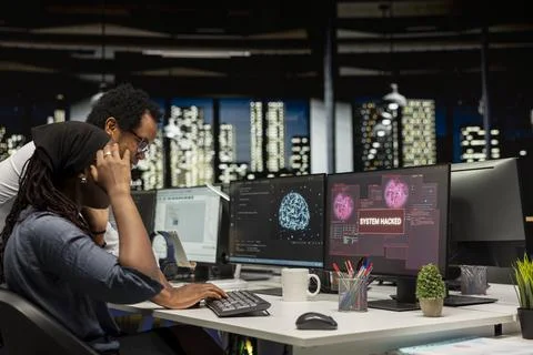 Young female programmer in office requests help from manager to block hacker Stock-Fotos