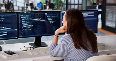 Young Female Programmer Sits At Her Desk Feeling Bored While Coding. Stock-Fotos