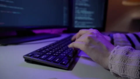 Young female programmer is sitting in office and coding new software typing on Stock Footage 151720455