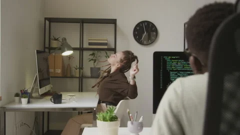 Young Female Programmer Stretching Arms while Sitting at Workplace Stock Footage 255781420