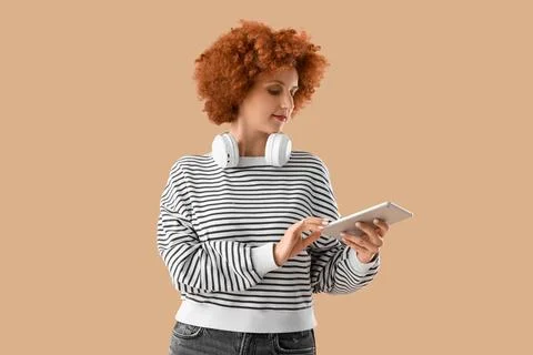 Young female programmer with tablet computer on beige background Stock Photos