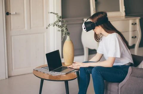 Young female programmer testing a new app with virtual reality glasses in home Stock-Fotos