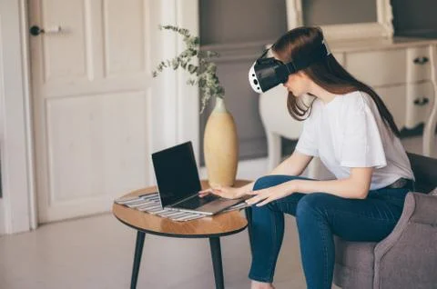 Young female programmer testing a new app with virtual reality glasses in home Stock-Fotos