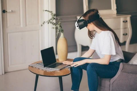 Young female programmer testing a new app with virtual reality glasses in home Stock-Fotos