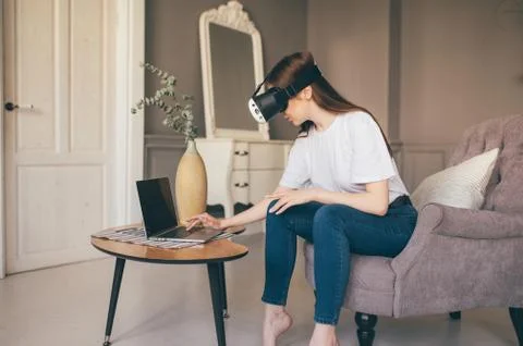 Young female programmer testing a new app with virtual reality glasses in home Stockfoto's