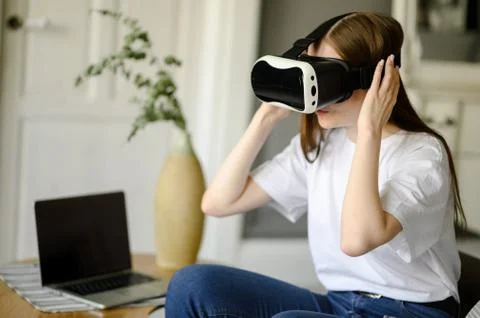 Young female programmer testing a new app with virtual reality glasses in home Stock-Fotos