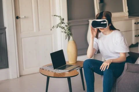 Young female programmer testing a new app with virtual reality glasses in home Fotos Stock